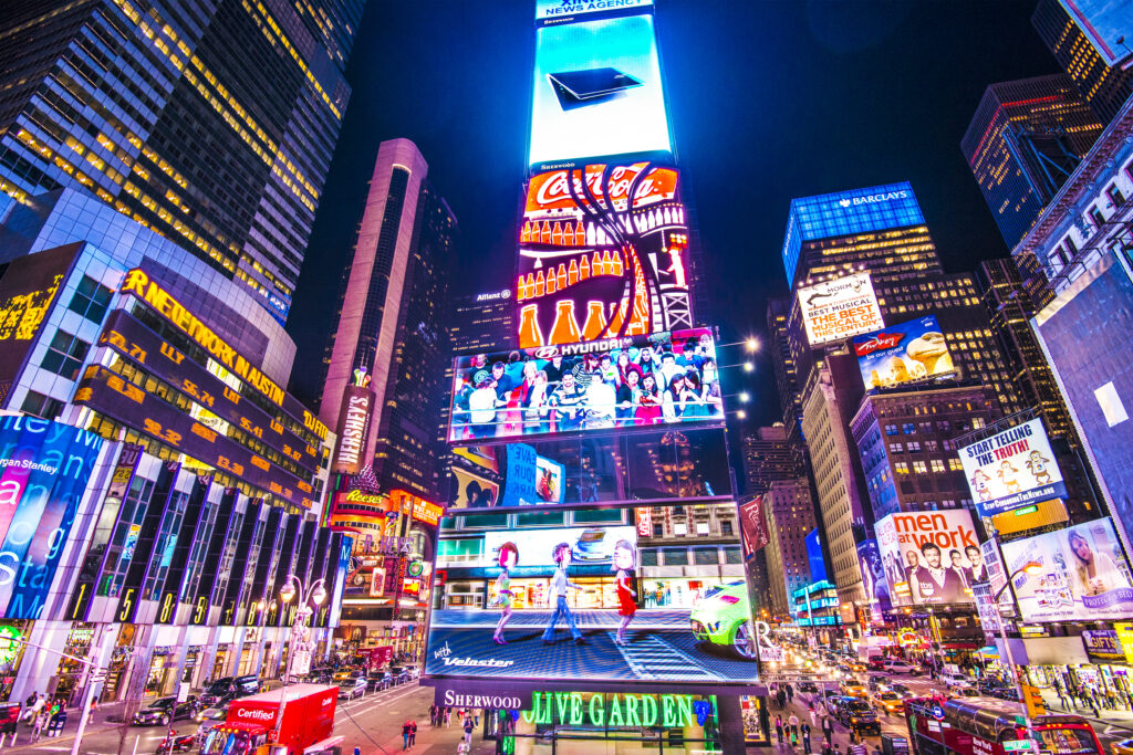 Times Square illuminated at night with bright advertising screens during the Night Lights of Westchester County private limousine tour